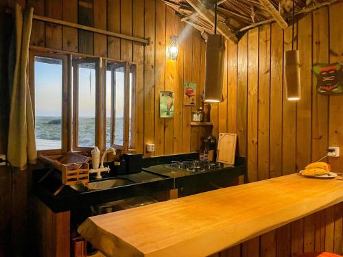a kitchen with wooden walls and a counter with a window at Arpoador Eco-Lodge in Tutóia