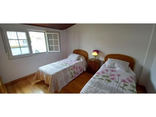 - une chambre avec 2 lits et une fenêtre dans l'établissement Carnota Beach, à San Mamede de Carnota