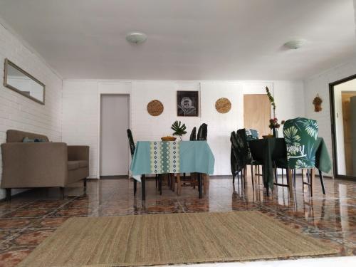 a dining room with a blue table and chairs at Hotel Hanau'eepe in Hanga Roa