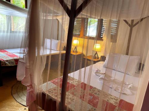 a room with a window with curtains and a bed at Jumapili Beach Villa in Ushongo Mabaoni