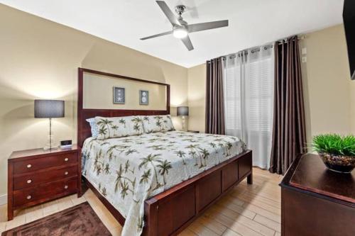 a bedroom with a bed and a dresser and a ceiling fan at AQUA 1504 Beachfront condo with Free Beach Chairs in Panama City Beach