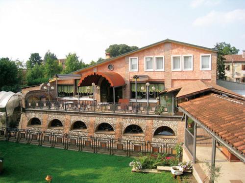 a large building with a patio and a train station at Hotel Il Chiostro in Oppeano