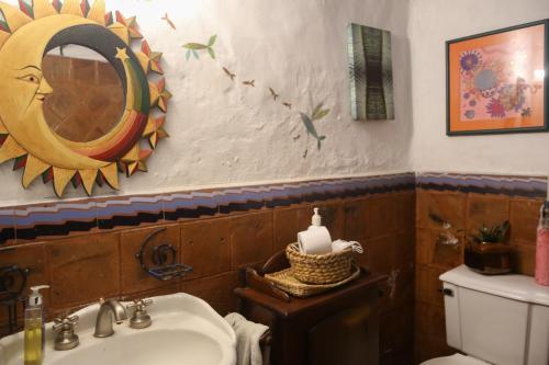 a bathroom with a sink and a mirror and a toilet at Espacio Pueblo. Galería rural in Amaguaña