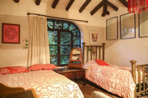 een slaapkamer met 2 bedden en een raam bij Espacio Pueblo. Galería rural in Amaguaña
