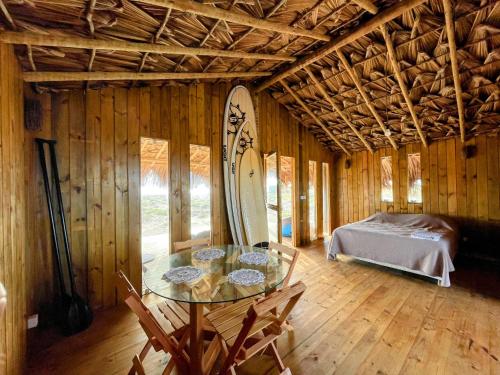 a room with a table and a surfboard in it at Arpoador Eco-Lodge in Tutóia