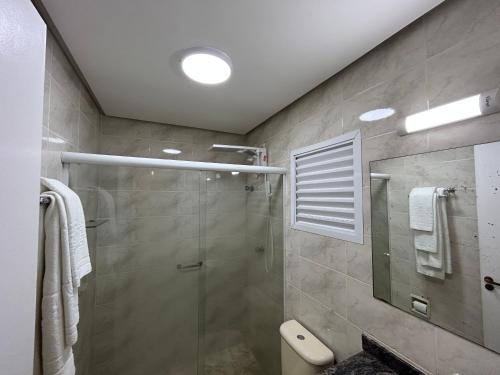 a bathroom with a shower and a glass shower stall at Flat Estudio 220 amarílis 3 Piscinas climatizadas, sky com 170 canais carregar veiculo eletrico, Bertioga, Riviera de São Lourenço Apartamento estúdio, cozinha equipada completa, serviço de hotelaria, limpeza e trocas diária de toalhas, WI-FI 500 MB in Riviera de São Lourenço