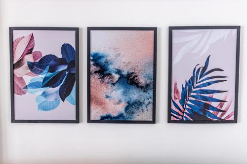 three framed prints of plants on a wall at Uai House com jacuzzi, teto rooftop retrátil e colchão massageador in Poços de Caldas