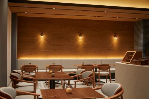 a dining room with wooden tables and chairs at HOTEL SAILS in Osaka
