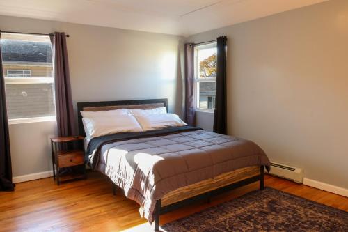 a bedroom with a bed and two windows at BGI Rentals in Brooklyn