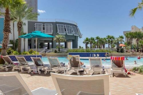 a pool with chaise lounge chairs and a resort at Laketown Wharf 1233 luxury condo in Panama City Beach
