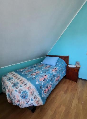 a bed in a room with a blue wall at Casa Villa residencial in Maquegua
