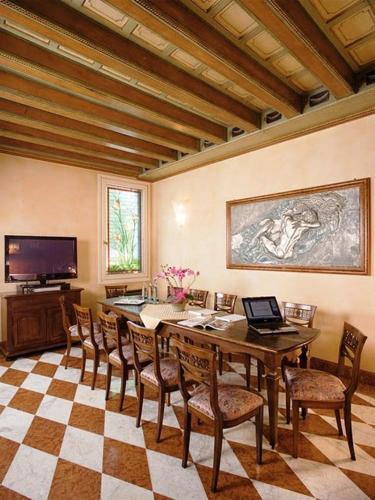 a dining room with a table and chairs with a laptop at Hotel Il Chiostro in Oppeano