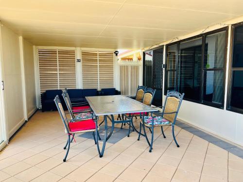 einen Tisch und Stühle auf einer Terrasse mit einem Sofa in der Unterkunft Wallaroo Sunset home in Wallaroo