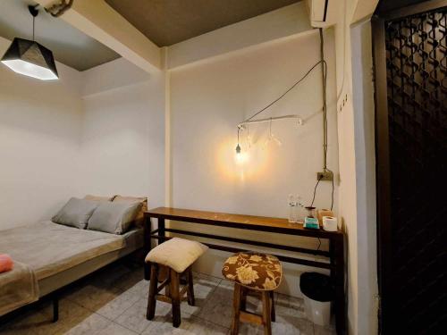 a room with a bed and a desk with a bed and chairs at 8 SLEEPER STREET Guesthouse in Krabi town