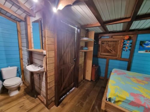 a bathroom with a toilet and a sink in a room at Lodge grenadine in Deshaies