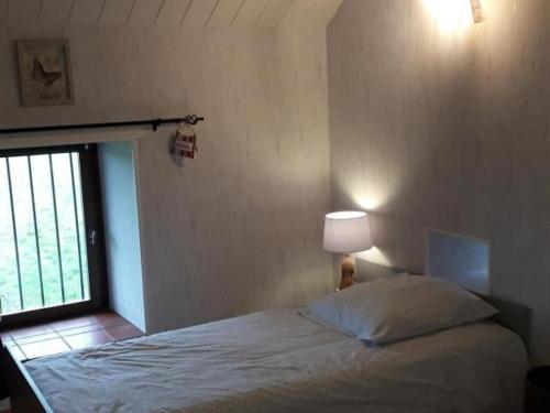 um quarto com uma cama com um candeeiro e uma janela em Gîte La Petite-Marche, 3 pièces, 4 personnes - FR-1-489-159 em La Petite-Marche