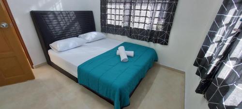 um quarto com uma cama com uma cruz em SDA Homestay Pool @StadiumDarulAman Untuk Muslim Sahaja em Alor Setar