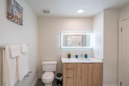 a bathroom with a toilet and a sink and a mirror at Apartment with Panoramic Views & Free parking! in Los Angeles