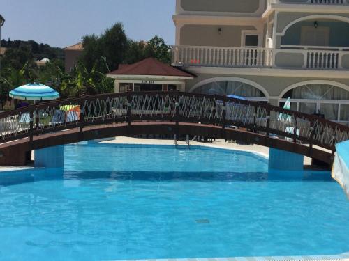 a bridge over a pool in front of a building at Hotel Villa Basil in Tsilivi