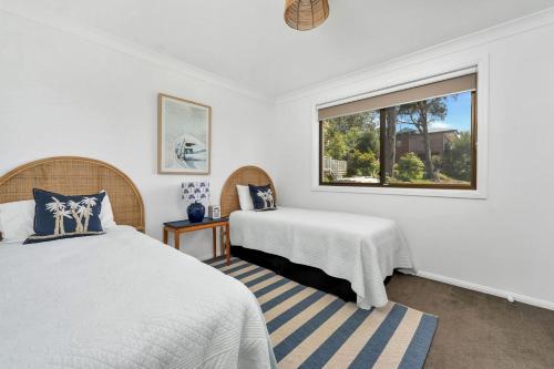 une chambre avec deux lits et une fenêtre dans l'établissement Sandals at the Bay Upstairs sleeps 6 Hyams Beach, à Hyams Beach