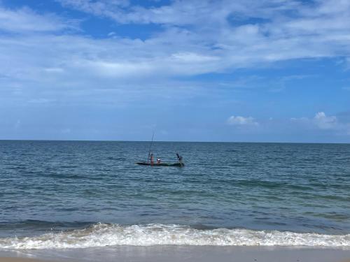 two people are in a boat in the ocean at Jumapili Beach Villa in Ushongo Mabaoni