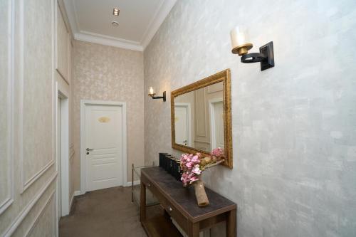 a hallway with a mirror and a table with flowers at Zimmer Boutique Hotel in Baku