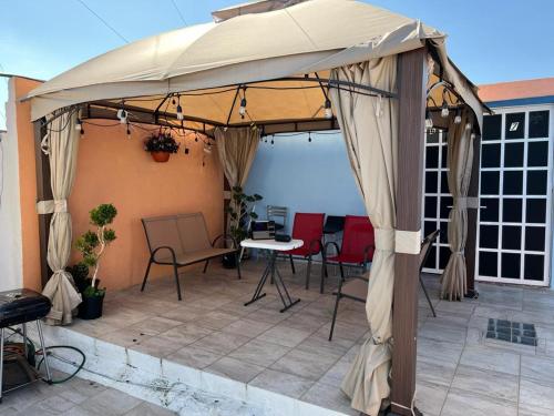 einen Pavillon mit Stühlen und einen Tisch auf der Terrasse in der Unterkunft Estancia María Bonita Morelia in Morelia
