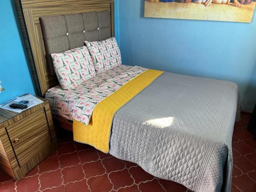 a bedroom with a bed and a nightstand with a bed sidx sidx at Estancia María Bonita Morelia in Morelia