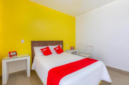 a bedroom with a large bed with red pillows at Hotel Rincón de los 3 Ángeles in Asunción Nochixtlán