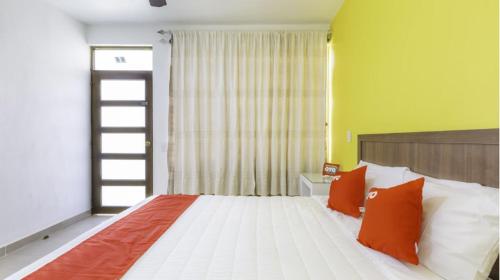 a bedroom with a bed with orange and white pillows at Hotel Rincón de los 3 Ángeles in Asunción Nochixtlán