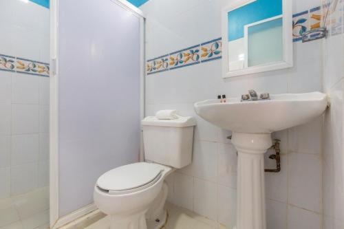 a bathroom with a white toilet and a sink at Hotel Rincón de los 3 Ángeles in Asunción Nochixtlán