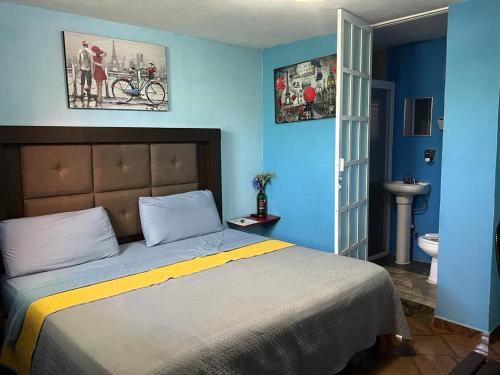 モレリアにあるEstancia María Bonita Moreliaの青いベッドルーム(ベッド1台、バスルーム付)