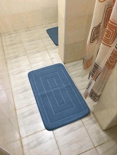 a blue floor mat on the floor of a bathroom at Ajay's residence in Hanya