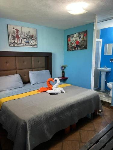 a bedroom with a bed with a swan on it at Estancia María Bonita Morelia in Morelia