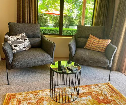 a living room with two chairs and a coffee table at Studio 585 in Alexandra