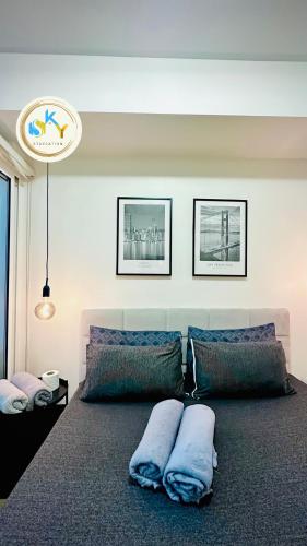 a bedroom with a large bed with pillows on it at 1BR Condo Unit at Celandine Condominium Near Ayala Cloverleaf Mall in Manila