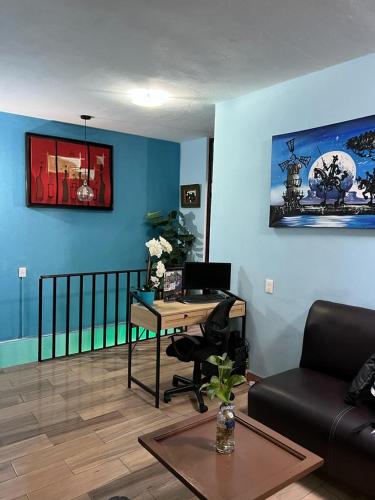 a living room with a desk and a couch at Estancia María Bonita Morelia in Morelia