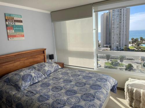 1 dormitorio con cama y ventana grande en Moderno departamento acceso a playa, en Coquimbo