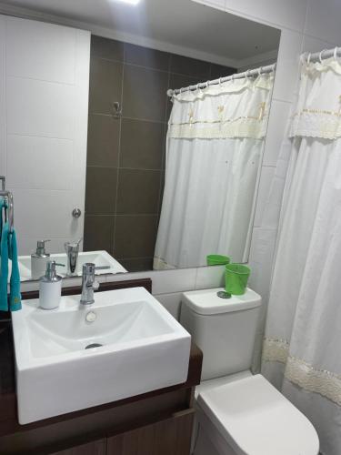 Baño blanco con lavabo y aseo en Moderno departamento acceso a playa, en Coquimbo