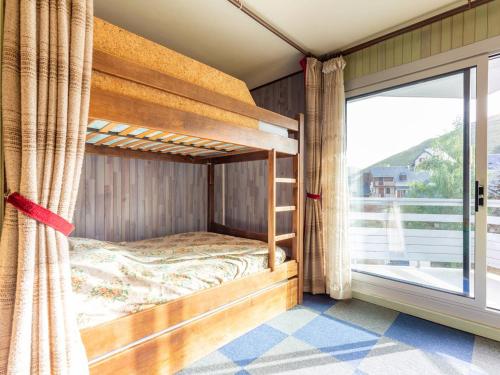 a bedroom with bunk beds and a large window at Studio Peyragudes, 1 pièce, 4 personnes - FR-1-695-39 in Germ