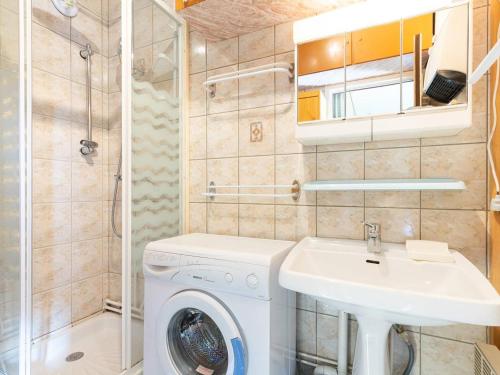 une salle de bain avec une machine à laver et un lavabo dans l'établissement Studio cosy pour 4 à Peyragudes proche des commerces - FR-1-695-39, à Germ