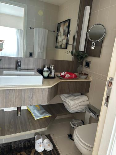 a bathroom with a sink and a toilet and a mirror at Flat no Itaim in São Paulo