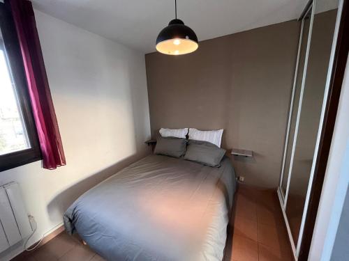 une petite chambre avec un lit dans le coin dans l'établissement face au lac marin, au Barcarès