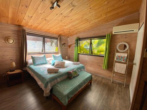 1 dormitorio con 2 camas en una cabaña de madera en Teanuhe Hills, en Faaa