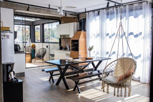 a kitchen and dining room with a table and chairs at Uai House com jacuzzi (Espaço romântico) in Poços de Caldas