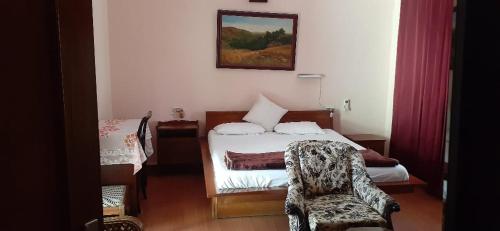 a small bedroom with a bed and a chair at vera home stay in Dehradun