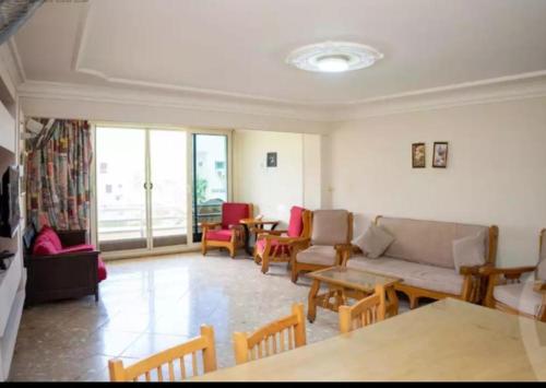 ein Wohnzimmer mit einer Couch sowie Tischen und Stühlen in der Unterkunft شاليه دوبلكس سوبر لوكس في المعموره الشاطئ الاسكندريه من الما لك مباشر اطلاله رائعه بجوار فندق هلنان كارنيهات الشاطئ الخاص vip عائلات فقط Luxury Duplex Chalet in Mamoura Beach Alexandria open view Beside Helnan Hotel Beach Family only 0 1 0 0 1 2 2 8 7 7 9 in Alexandria