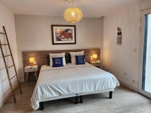 a bedroom with a large bed with blue pillows at Maison Vue Mer in Pornichet