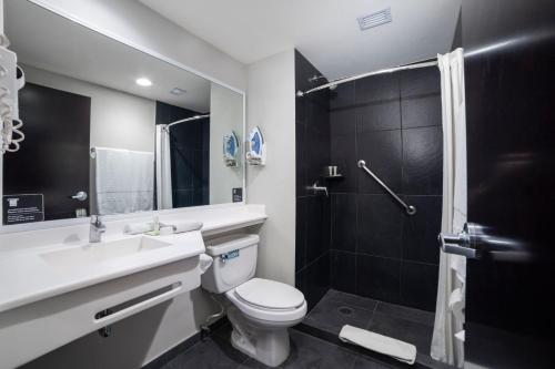 La salle de bains est pourvue de toilettes, d'un lavabo et d'une douche. dans l'établissement City Express Plus by Marriott Mexicali, à Mexicali