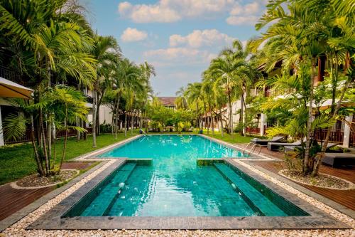 una piscina en un complejo con palmeras en Green Park Boutique Hotel, en Vientiane